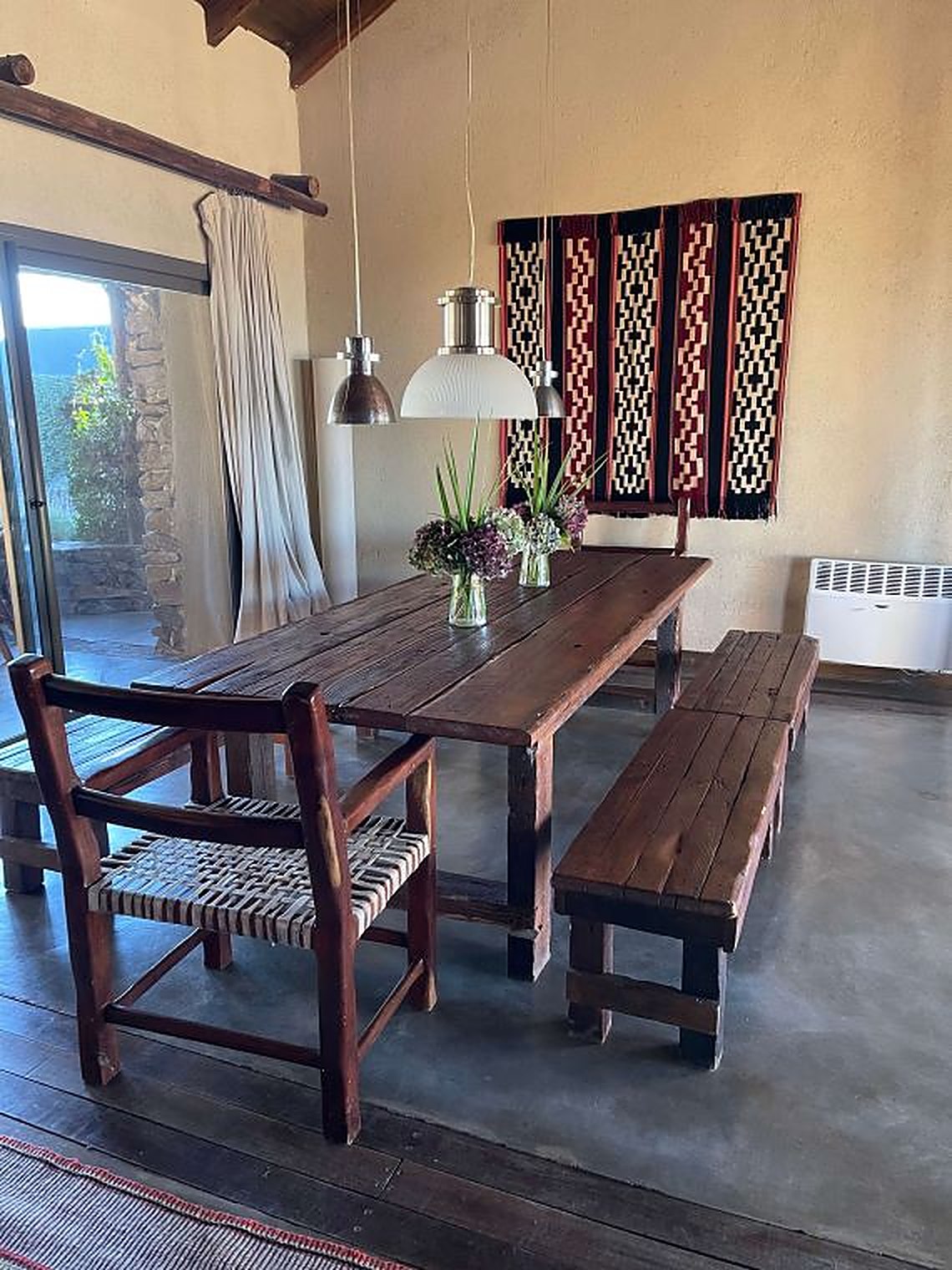 La sala comedor de Carahuasi — mesa larga, chimenea de piedra y textiles artesanales